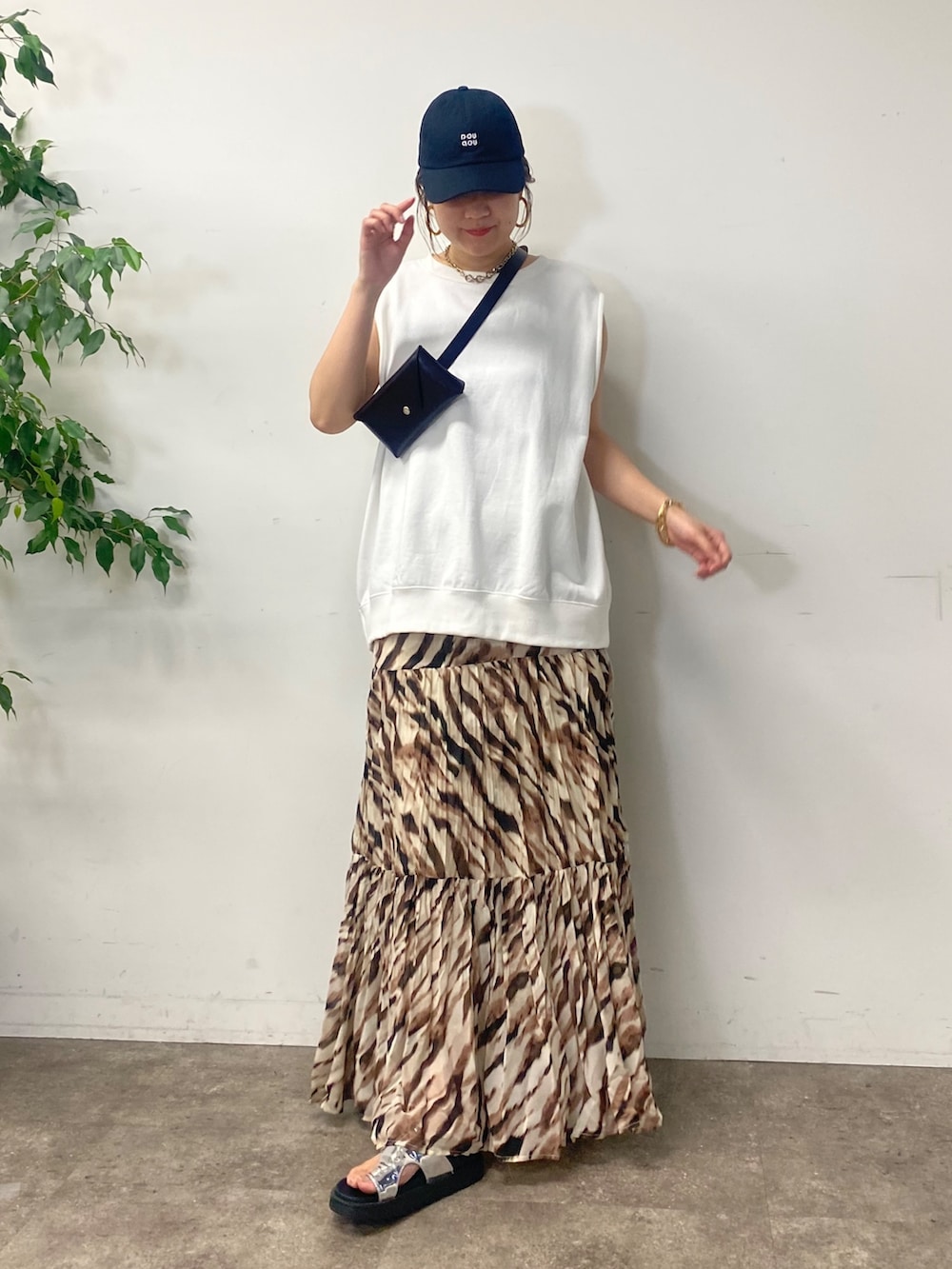 ブラック系のショルダーバッグ、ホワイト系のTシャツ/カットソー、ベージュ系のスカートを着用したレディースの夏コーディネートの7枚目の写真