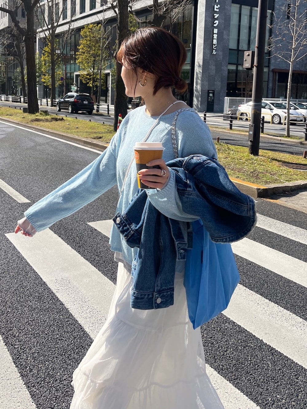 ブルー系のデニムジャケット、グレー系のニット/セーター、ホワイト系のTシャツ/カットソーを着用したレディースの春コーディネートの8枚目の写真