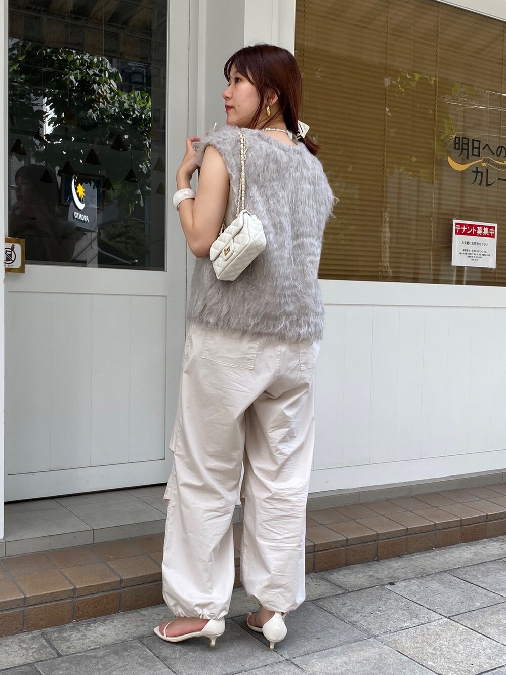 ベージュ系のベスト、ベージュ系のその他パンツ、ホワイト系のタンクトップを着用したレディースの秋コーディネートの5枚目の写真