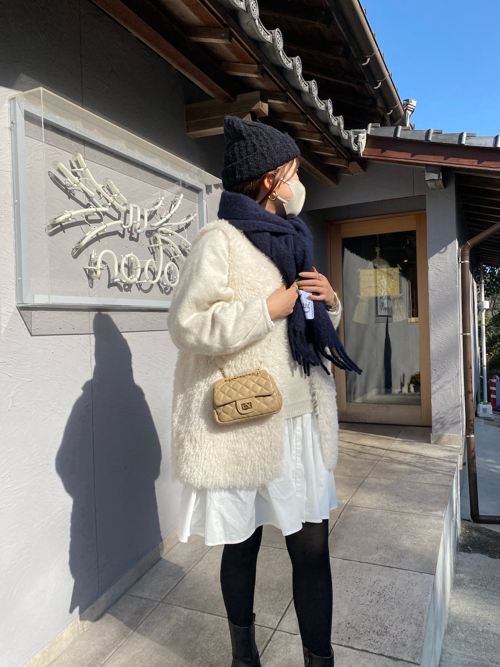 ホワイト系のベスト、ホワイト系のニット/セーター、ホワイト系のシャツ/ブラウスを着用したレディースの冬コーディネートの3枚目の写真