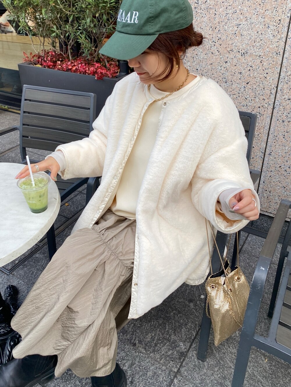 ホワイト系のダウンジャケット/コート、ゴールド系のショルダーバッグ、ホワイト系のワンピースを着用したレディースの冬コーディネートの9枚目の写真