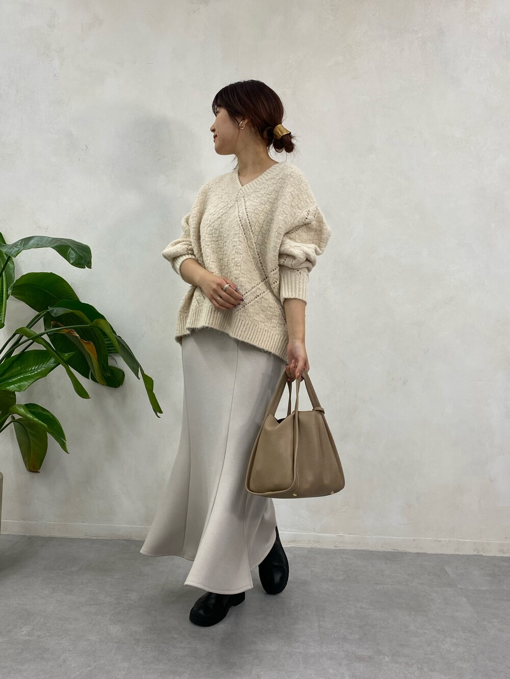 ホワイト系のニット/セーター、ベージュ系のトートバッグ、ベージュ系のスカートを着用したレディースの冬コーディネートの2枚目の写真