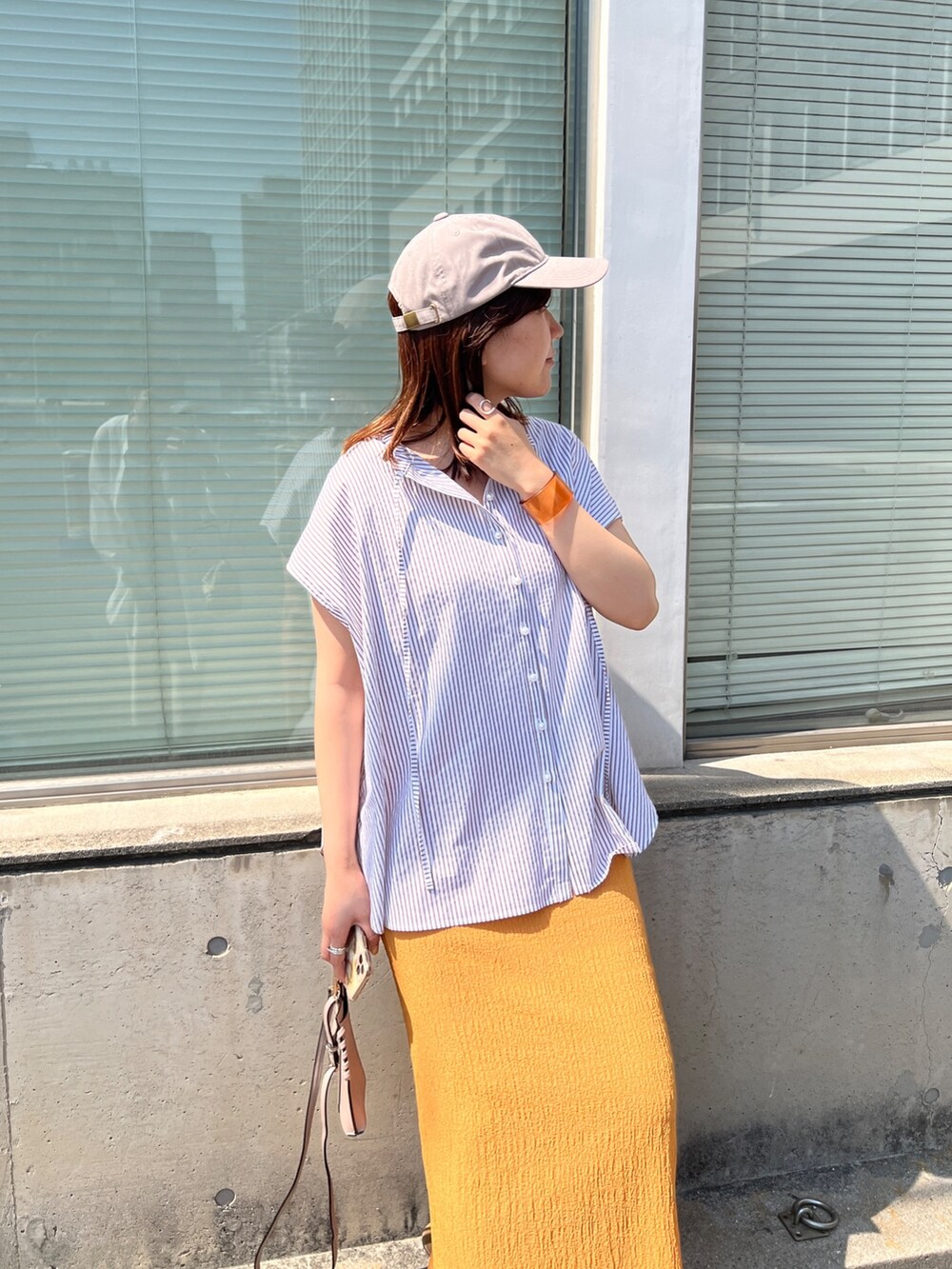 ベージュ系のシャツ/ブラウス、オレンジ系のスカート、ベージュ系のその他シューズを着用したレディースの夏コーディネートの2枚目の写真