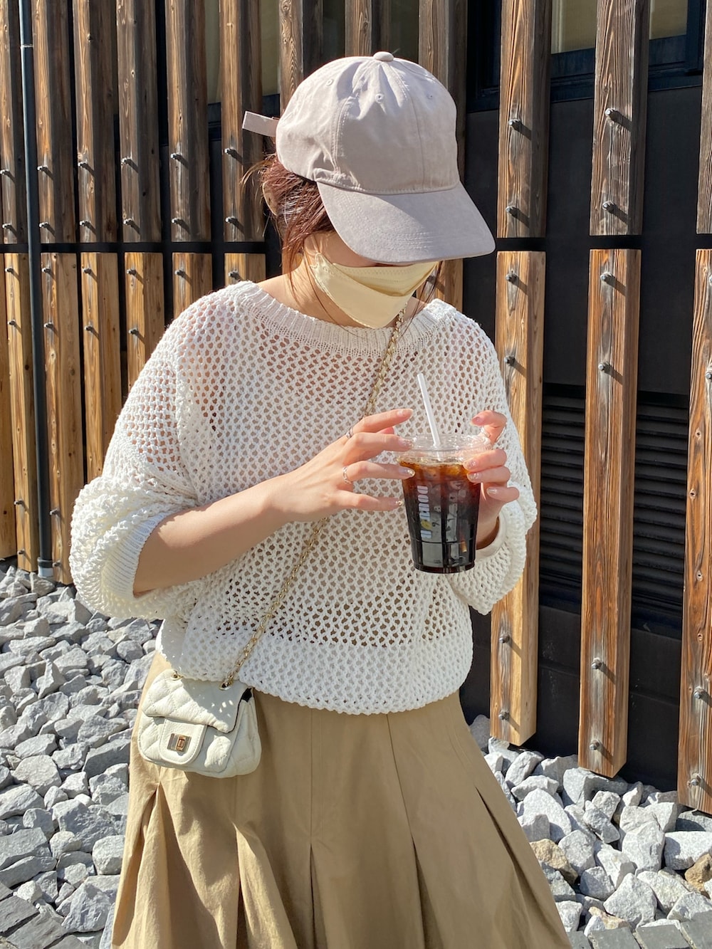 ホワイト系のニット/セーター、ベージュ系のスカート、ホワイト系のショルダーバッグを着用したレディースの春コーディネートの4枚目の写真