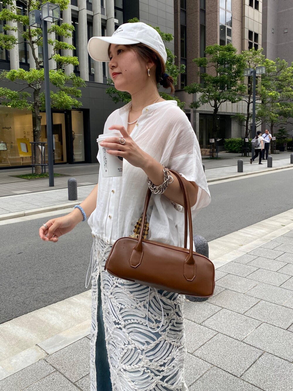 ピンク系のシャツ/ブラウス、ブルー系のデニムパンツ、ホワイト系のネックレスを着用したレディースの夏コーディネートの6枚目の写真