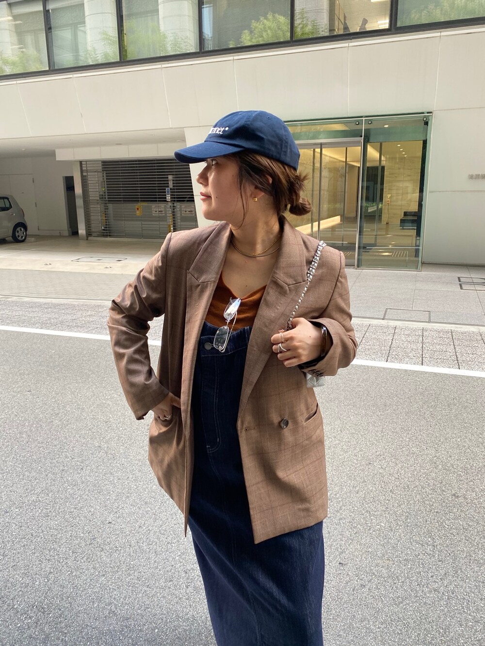 ブルー系のワンピース、シルバー系のショルダーバッグ、ブラウン系のテーラードジャケットを着用したレディースの夏コーディネートの4枚目の写真