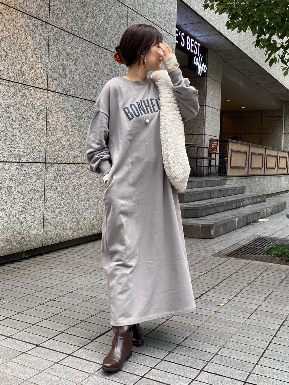 グレー系のワンピース、ブラウン系のブーツ、ゴールド系のTシャツ/カットソーを着用したレディースの秋コーディネートの8枚目の写真
