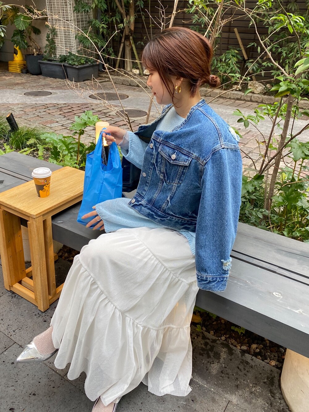 ブルー系のデニムジャケット、グレー系のニット/セーター、ホワイト系のTシャツ/カットソーを着用したレディースの春コーディネートの5枚目の写真