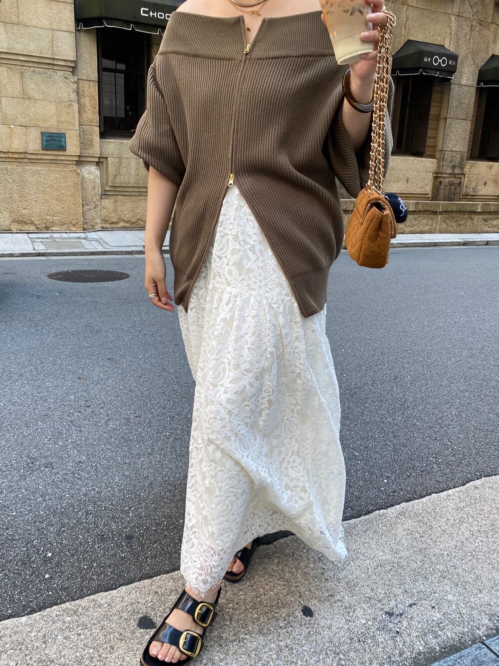 ブラウン系のニット/セーター、イエロー系のショルダーバッグ、ホワイト系のスカートを着用したレディースの秋コーディネートの4枚目の写真