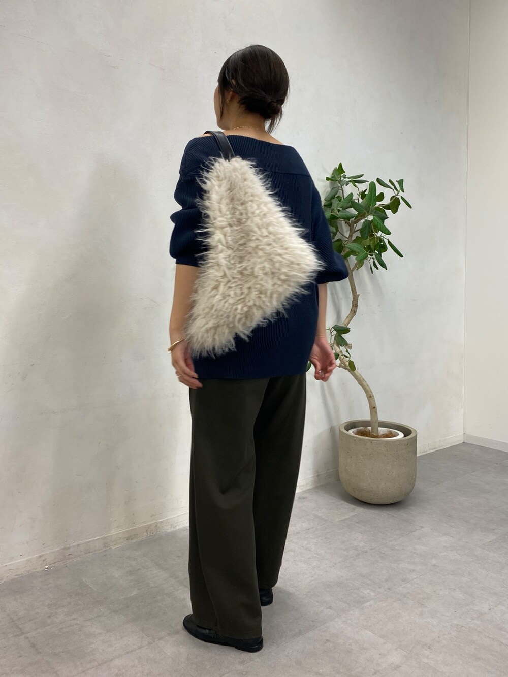 ブルー系のニット/セーター、グリーン系のその他パンツ、ホワイト系のショルダーバッグを着用したレディースの冬コーディネートの2枚目の写真