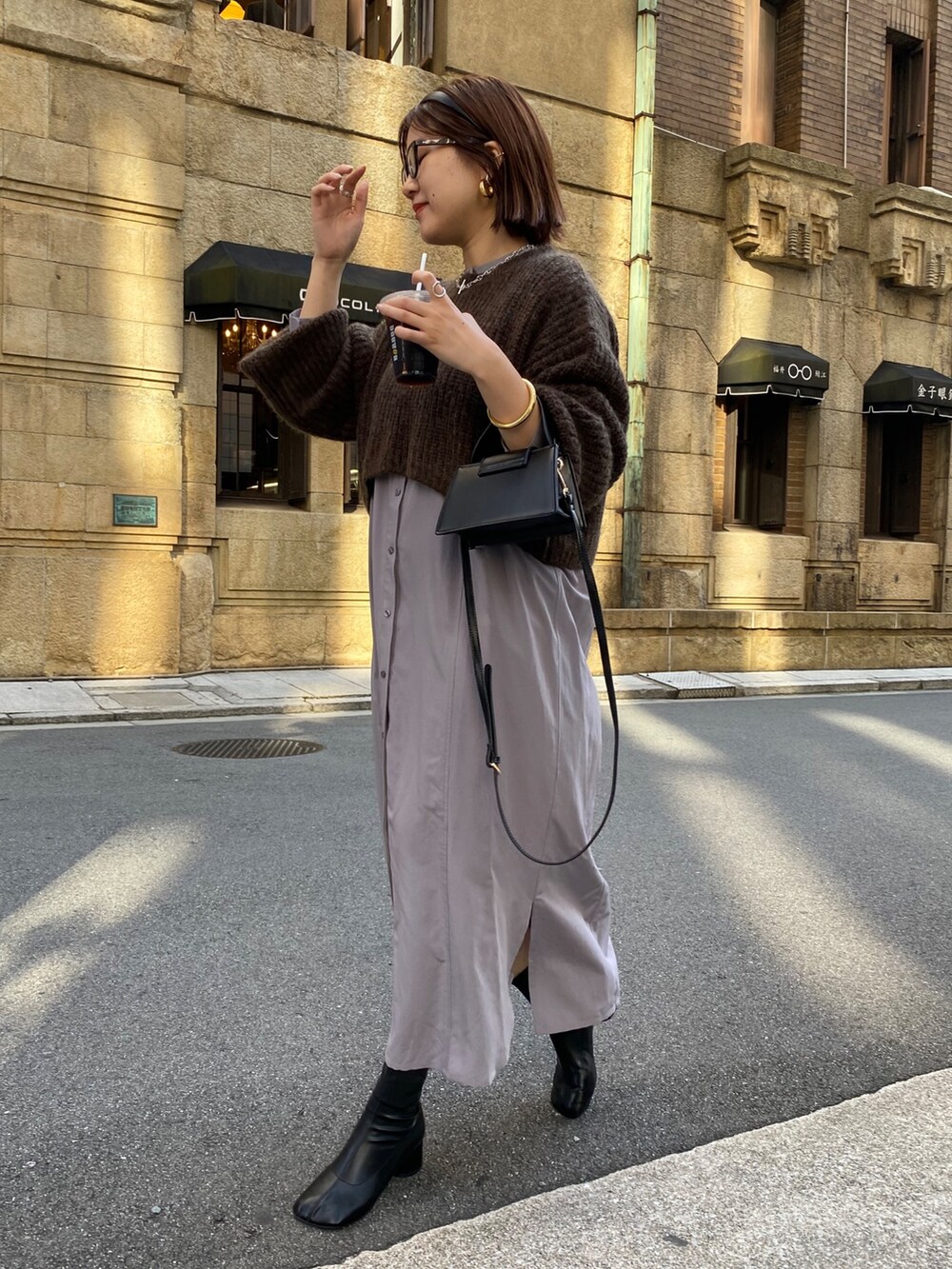 ブラウン系のワンピース、ブラック系のその他シューズを着用したレディースの秋コーディネートの2枚目の写真