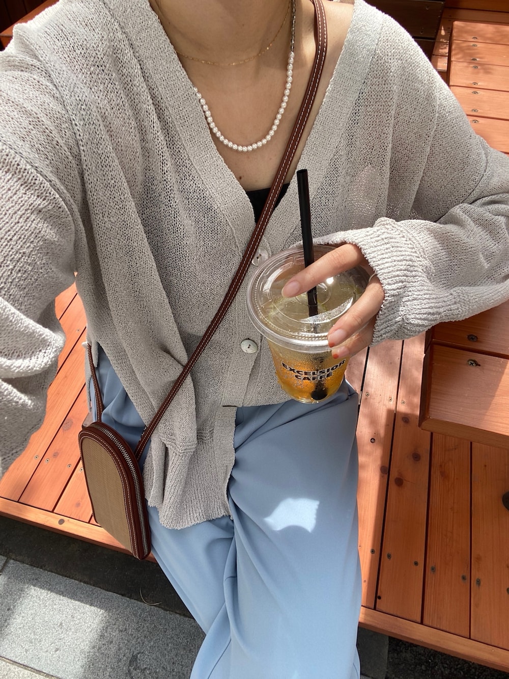 グレー系のカーディガン/ボレロ、ブルー系のスラックス、ゴールド系のサスペンダーを着用したレディースの夏コーディネートの9枚目の写真