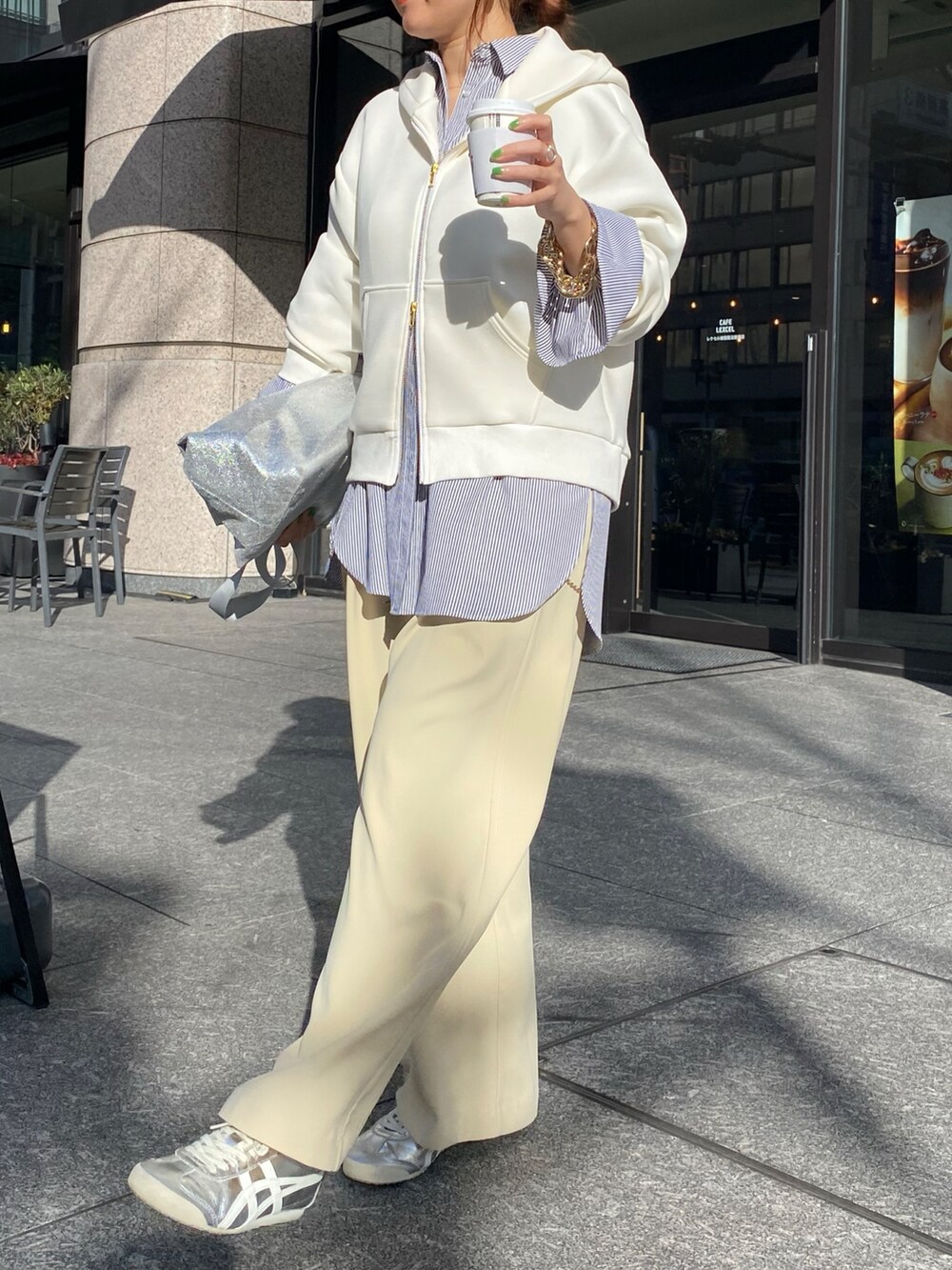 ホワイト系のパーカー、ブラック系のシャツ/ブラウス、イエロー系のスラックスを着用したレディースの冬コーディネートの7枚目の写真