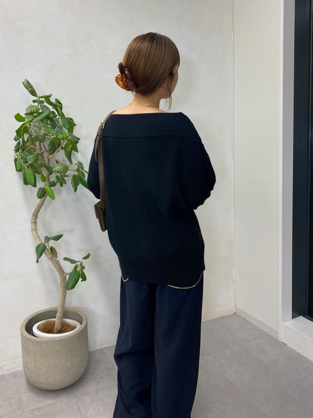 ブラック系のニット/セーター、ブルー系のスラックス、ゴールド系のサスペンダーを着用したレディースの秋コーディネートの4枚目の写真