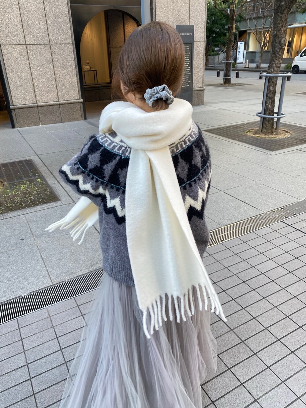 グレー系のカーディガン/ボレロ、ブルー系のTシャツ/カットソー、グレー系のスカートを着用したレディースの冬コーディネートの3枚目の写真