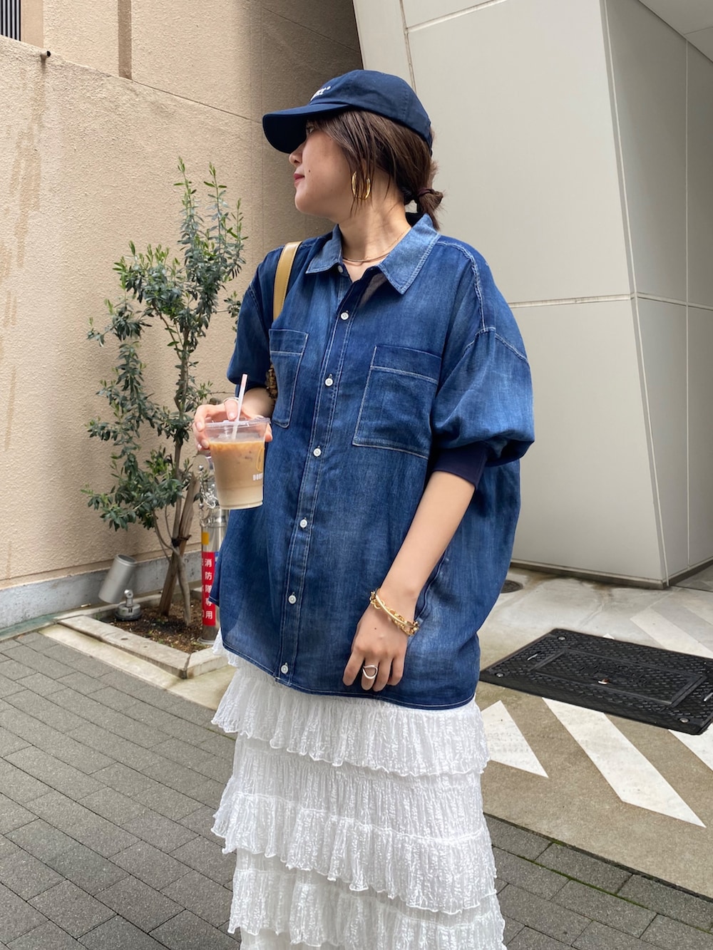 ブルー系のシャツ/ブラウス、ホワイト系のスカート、ゴールド系のネックレスを着用したレディースの春コーディネートの4枚目の写真