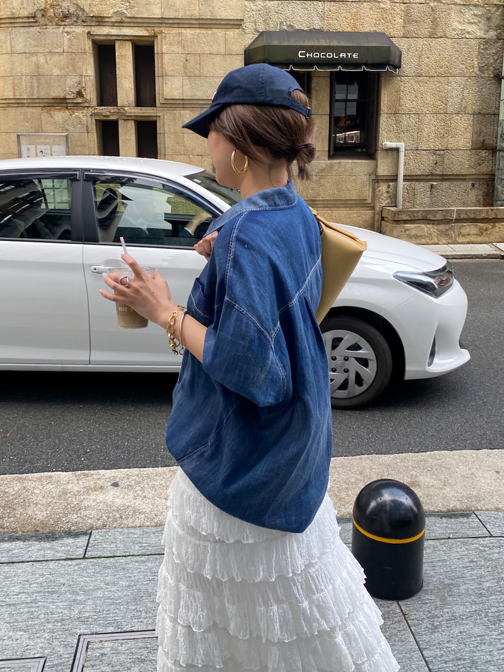 ブルー系のシャツ/ブラウス、ホワイト系のスカート、ゴールド系のネックレスを着用したレディースの春コーディネートの5枚目の写真