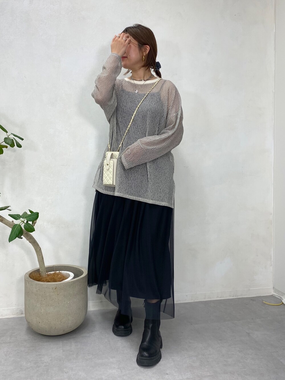 ブラック系のTシャツ/カットソー、ホワイト系のショルダーバッグ、ブラック系のスカートを着用したレディースの冬コーディネートの5枚目の写真