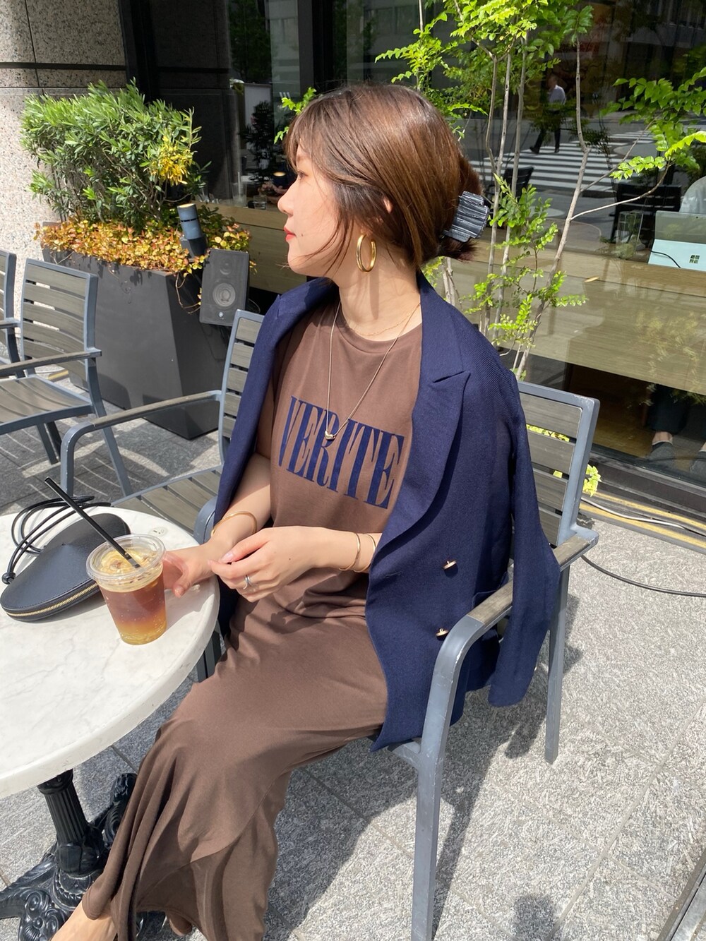 ブラウン系のTシャツ/カットソー、ブラウン系のスカート、ブラック系のショルダーバッグを着用したレディースの夏コーディネートの3枚目の写真