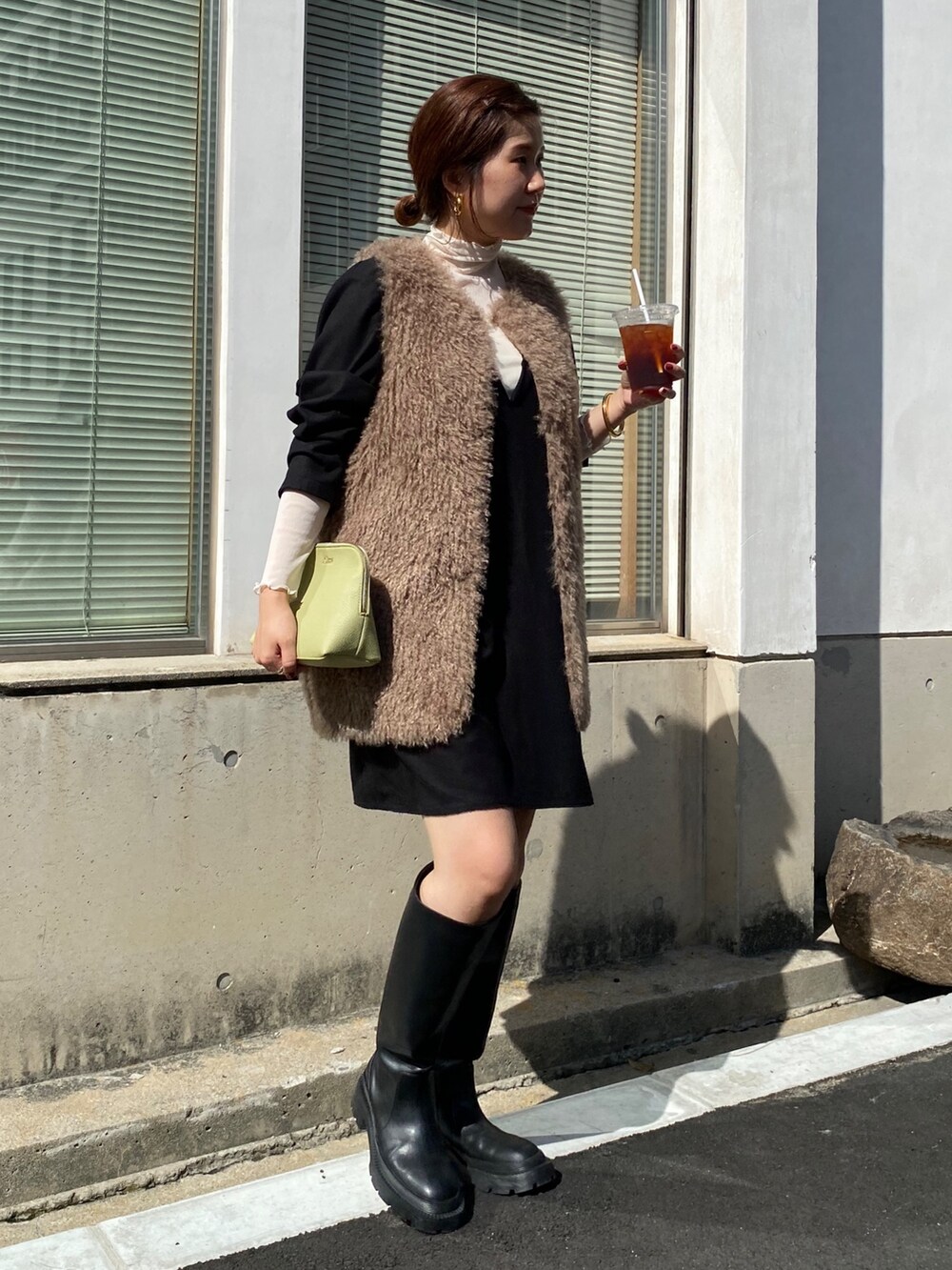 ベージュ系のベスト、ブラック系のワンピース、ブラック系のその他シューズを着用したレディースの秋コーディネートの2枚目の写真