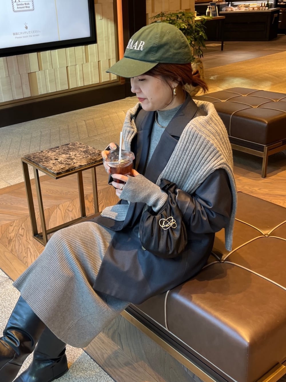 グレー系のテーラードジャケット、ベージュ系のワンピース、ブラック系のブーツを着用したレディースの冬コーディネートの4枚目の写真