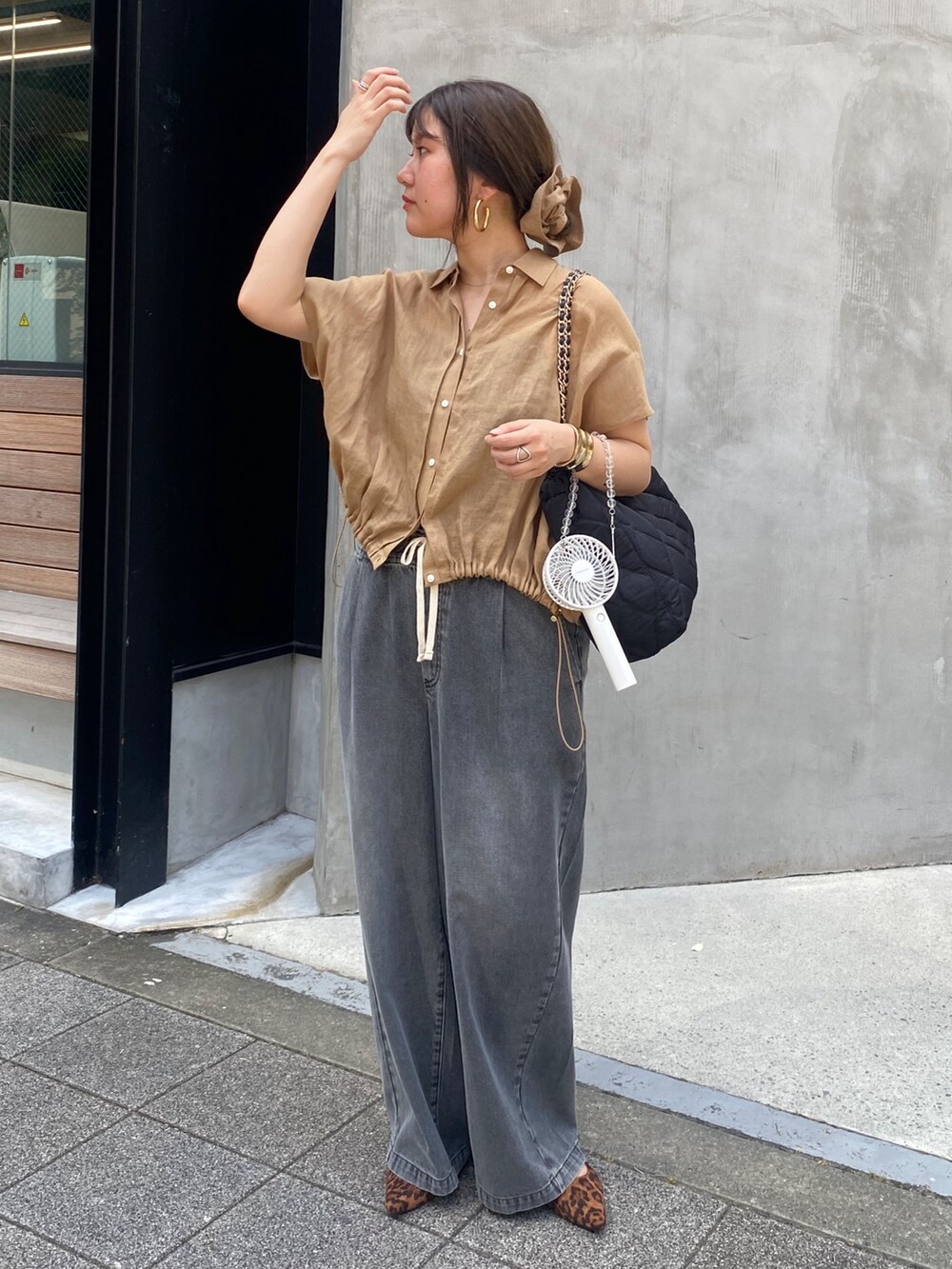ベージュ系のシャツ/ブラウス、ブラック系のデニムパンツ、ブラウン系のシュシュを着用したレディースの夏コーディネートの6枚目の写真