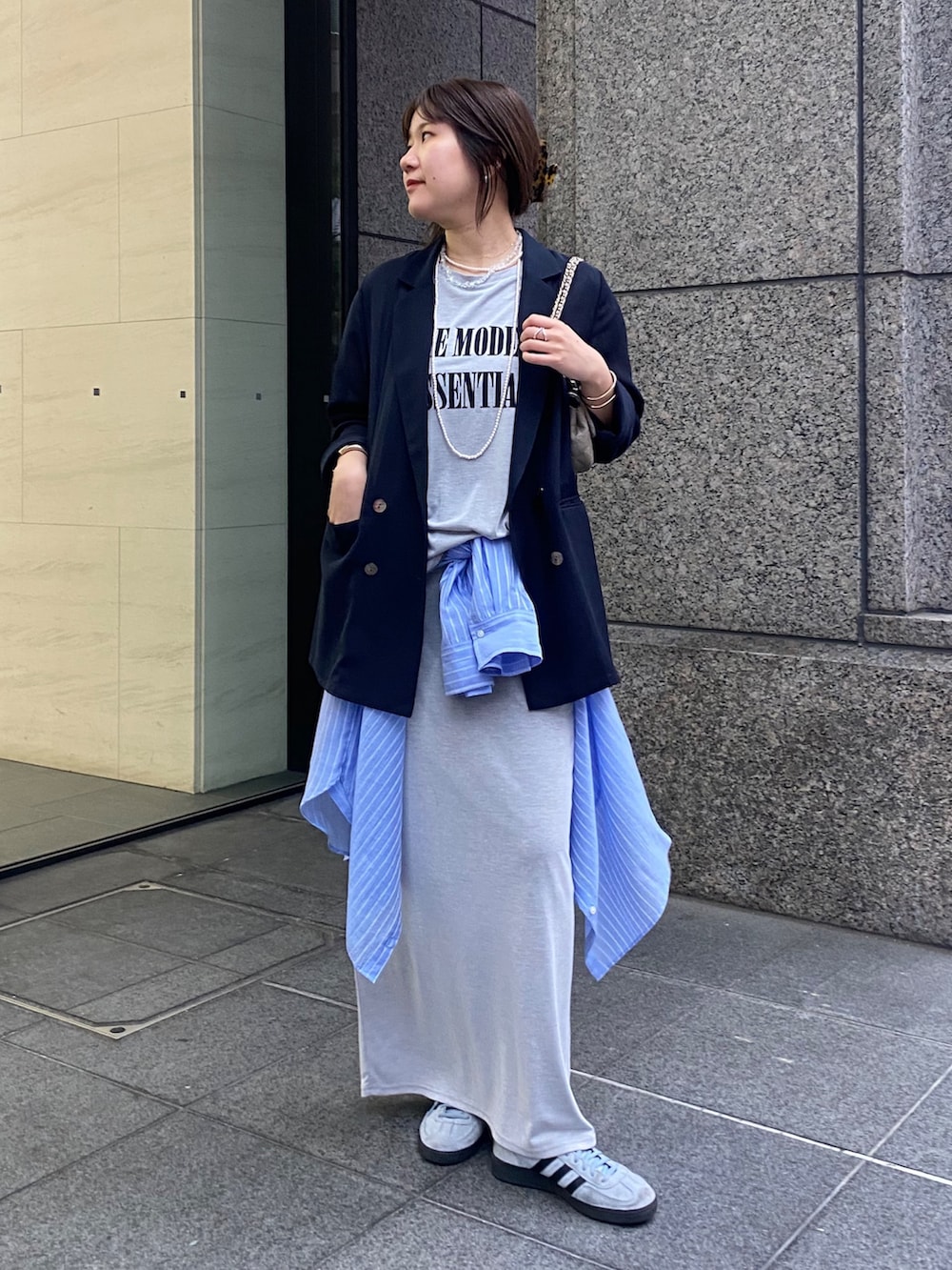 ブルー系のテーラードジャケット、グレー系のTシャツ/カットソー、グレー系のスカートを着用したレディースの春コーディネートの6枚目の写真