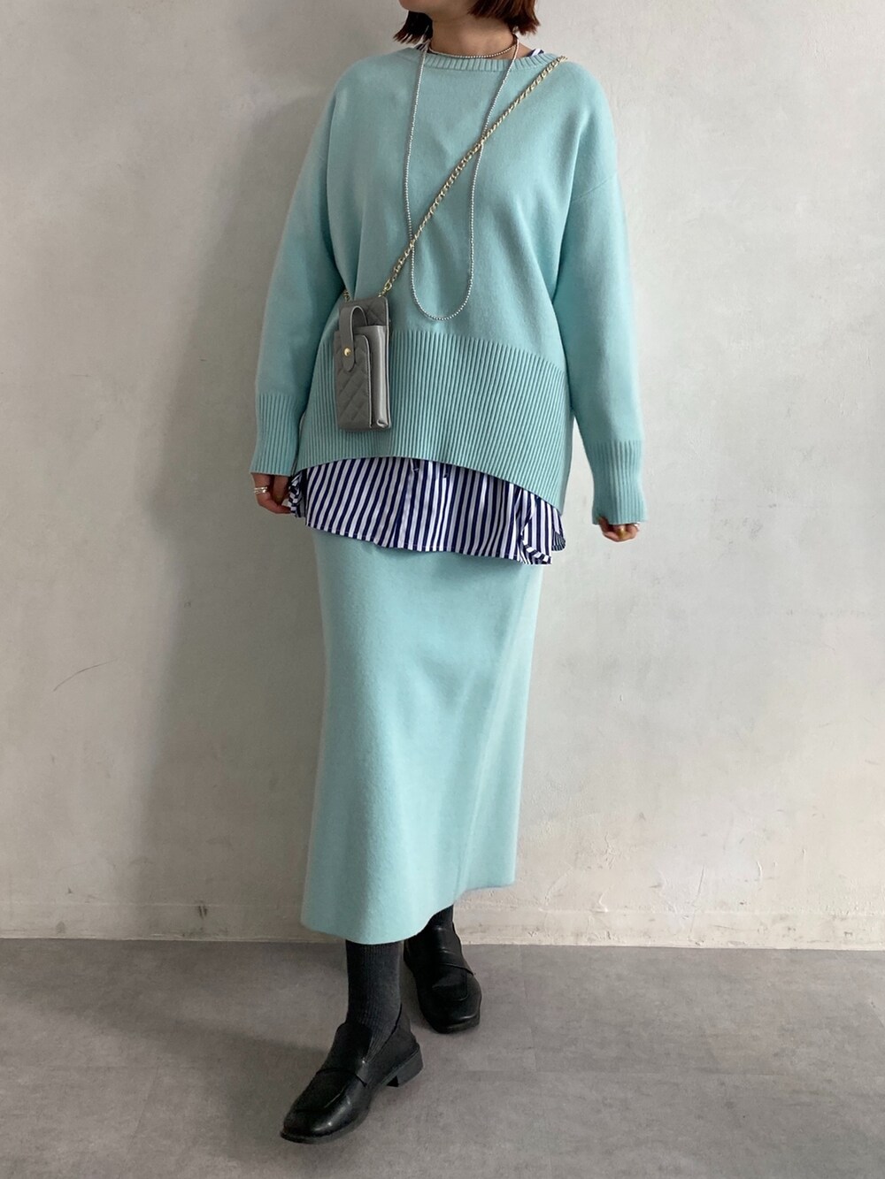 ブルー系のニット/セーター、ブルー系のシャツ/ブラウス、ブルー系のスカートを着用したレディースの冬コーディネートの2枚目の写真