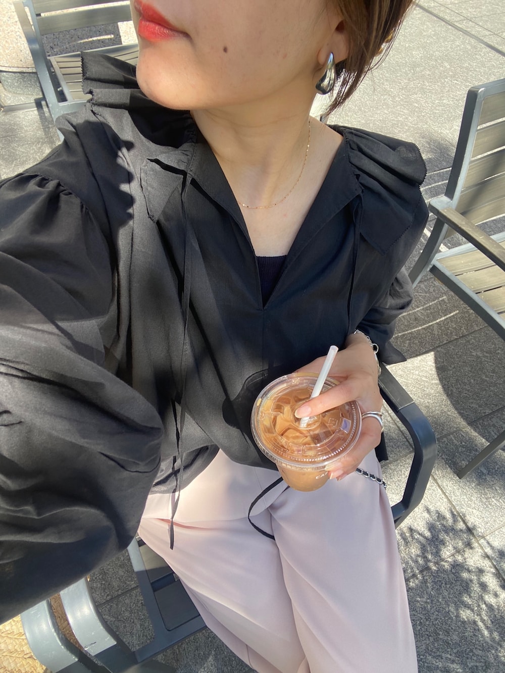 ブラック系のシャツ/ブラウス、ピンク系のスラックス、シルバー系のベルトを着用したレディースの夏コーディネートの8枚目の写真