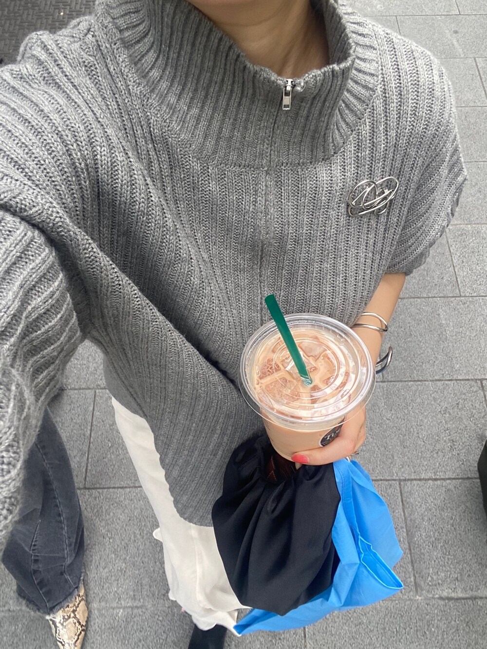 ベージュ系のワンピース、ホワイト系のスカート、ブラック系のブーツを着用したレディースの冬コーディネートの3枚目の写真