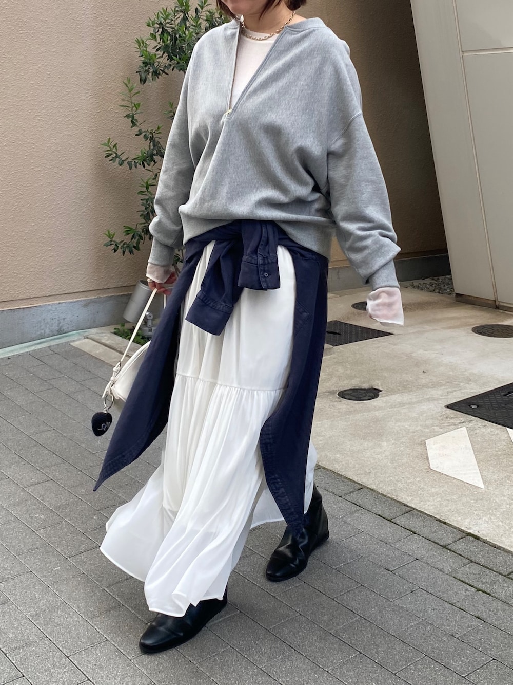 グレー系のスウェット、ブルー系のシャツ/ブラウス、ホワイト系のスカートを着用したレディースの冬コーディネートの4枚目の写真