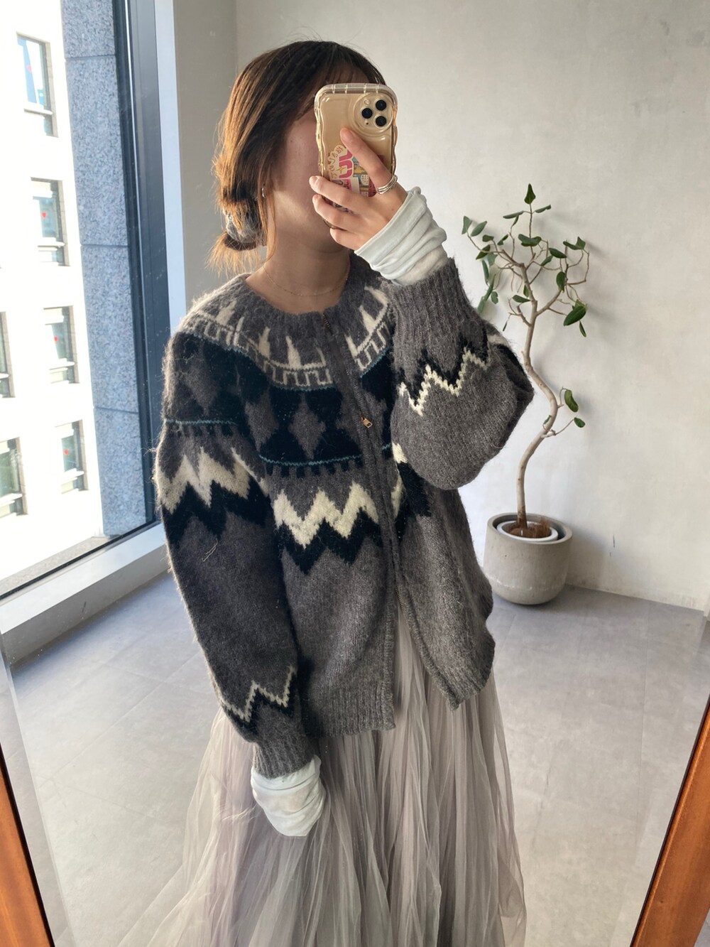 グレー系のカーディガン/ボレロ、ブルー系のTシャツ/カットソー、グレー系のスカートを着用したレディースの冬コーディネートの4枚目の写真