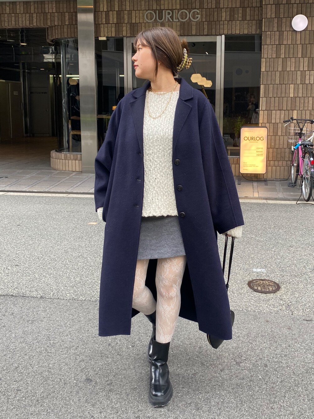 ホワイト系のニット/セーター、グレー系のスカート、ブラック系のショルダーバッグを着用したレディースの冬コーディネートの4枚目の写真