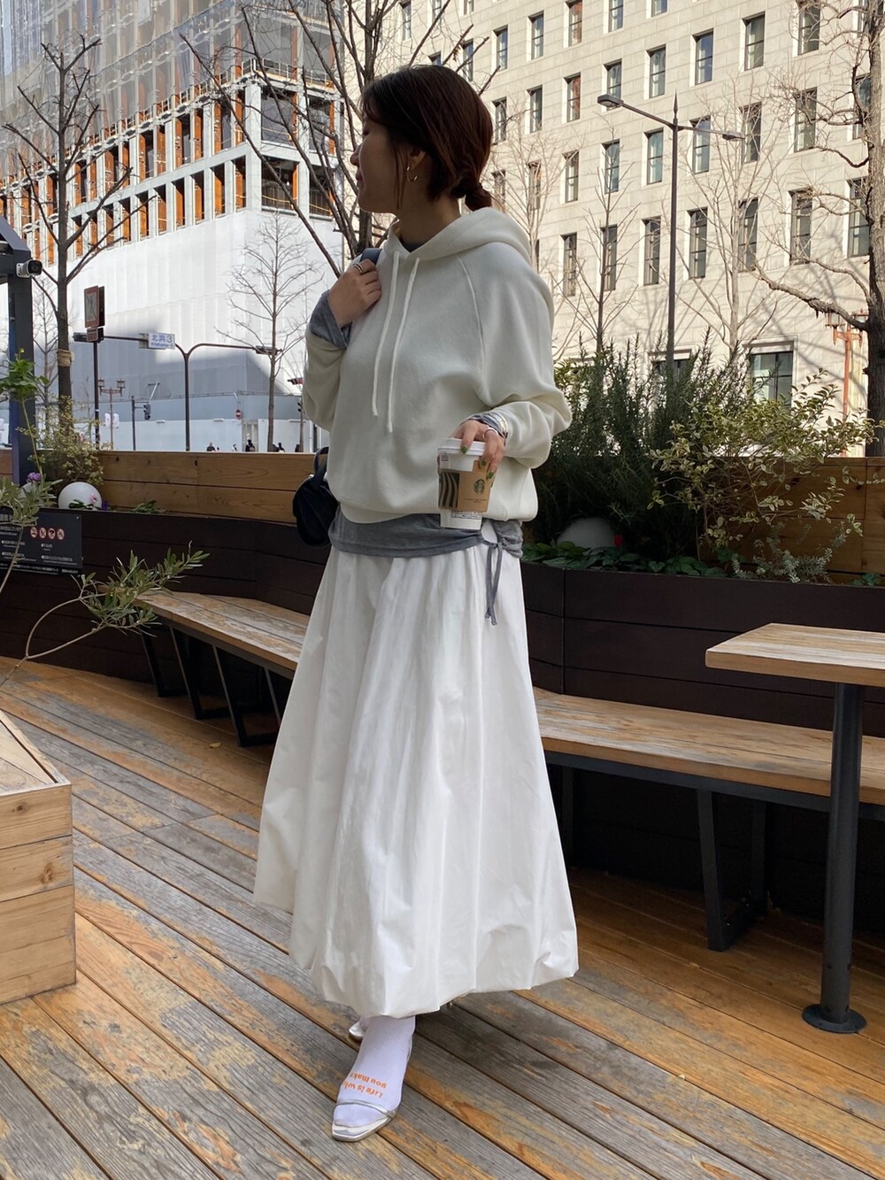 ホワイト系のスカート、ブラウン系のショルダーバッグ、グレー系のTシャツ/カットソーを着用したレディースの春コーディネートの9枚目の写真