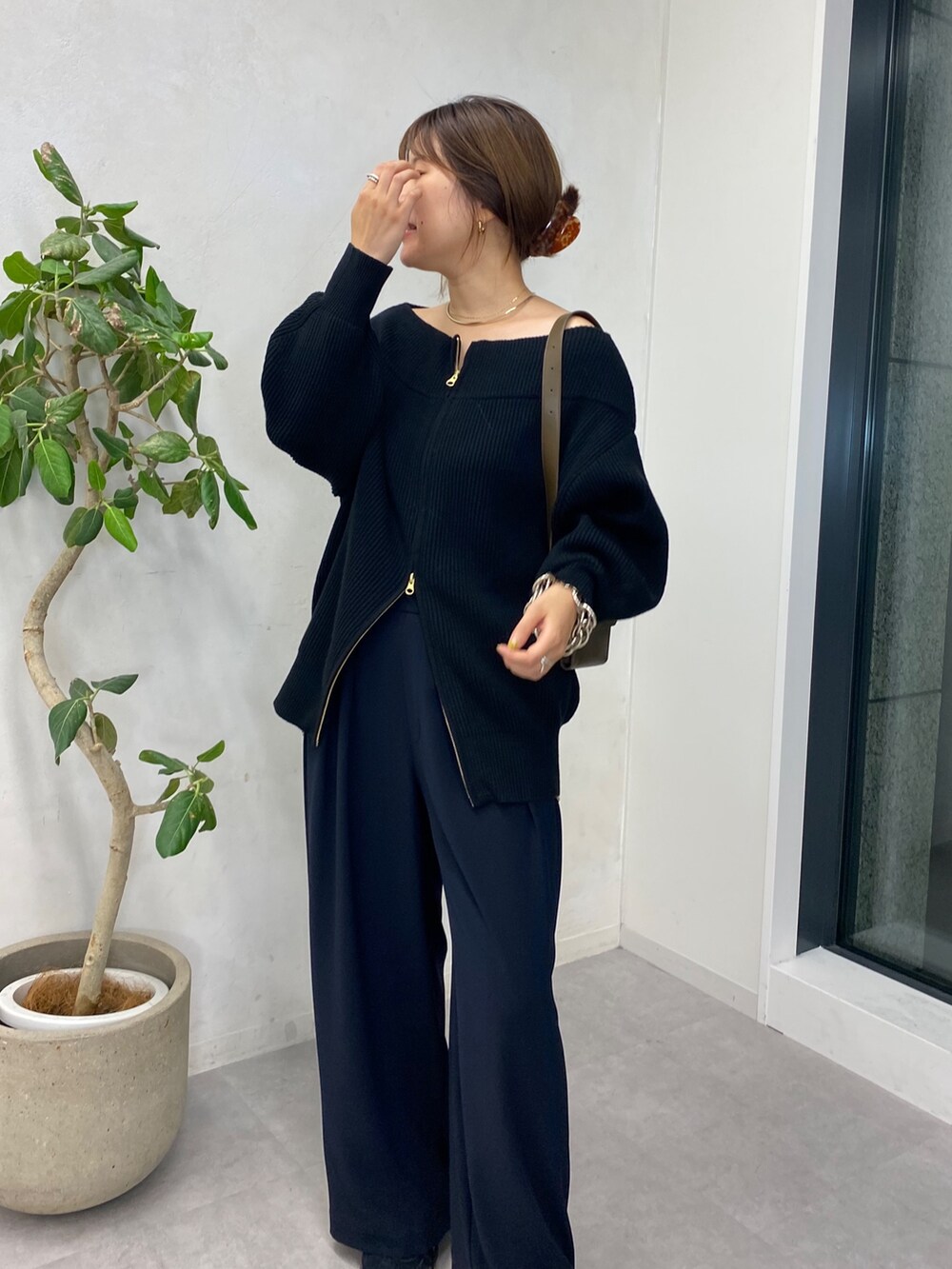 ブラック系のニット/セーター、ブルー系のスラックス、ゴールド系のサスペンダーを着用したレディースの秋コーディネートの3枚目の写真