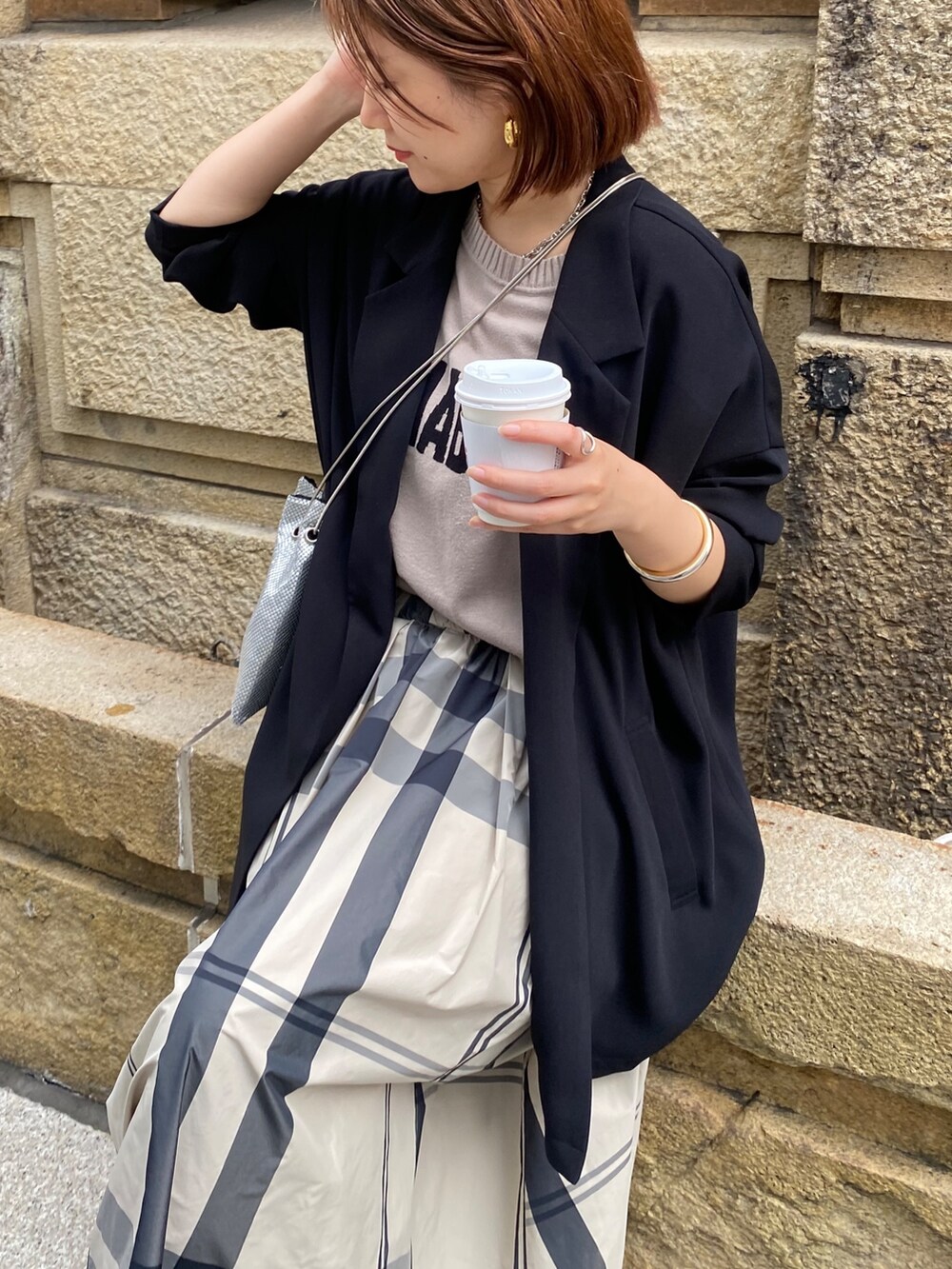 ベージュ系のニット/セーター、ベージュ系のスカート、ブラック系のサンダルを着用したレディースの冬コーディネートの5枚目の写真