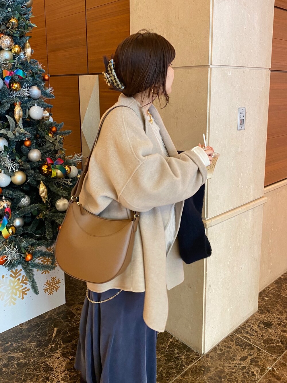 イエロー系のその他アウター、ホワイト系のニット/セーター、ホワイト系のスカートを着用したレディースの冬コーディネートの6枚目の写真