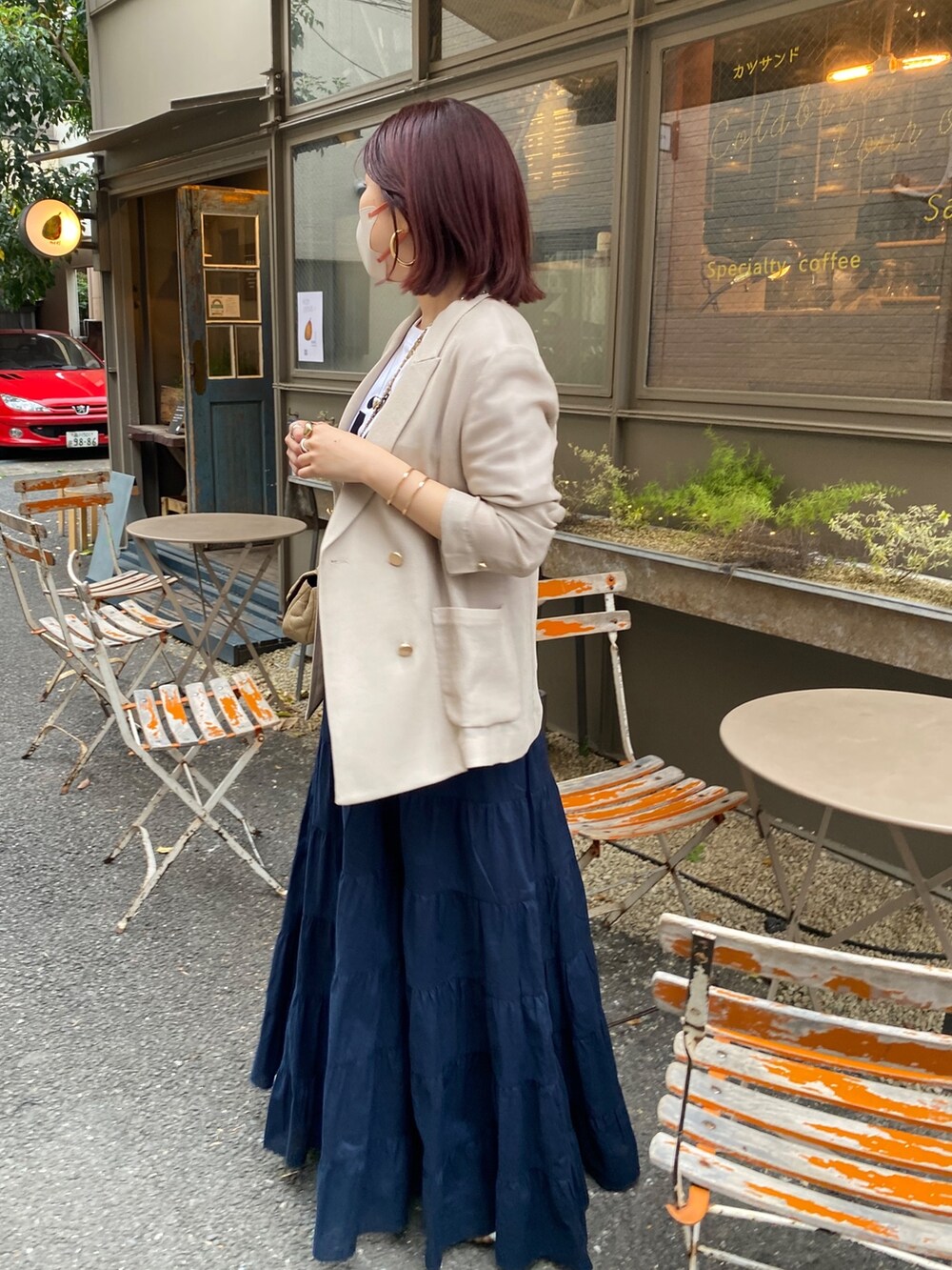 ベージュ系のテーラードジャケット、ホワイト系のTシャツ/カットソー、ブルー系のスカートを着用したレディースの春コーディネートの3枚目の写真