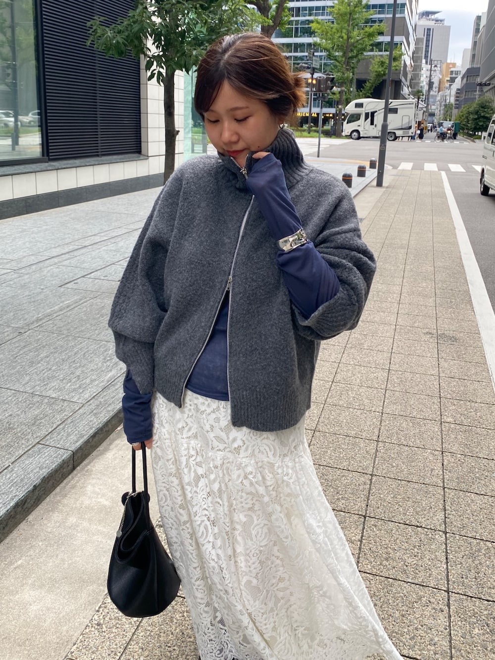 グレー系のカーディガン/ボレロ、ブルー系のTシャツ/カットソー、ホワイト系のスカートを着用したレディースの秋コーディネートの9枚目の写真