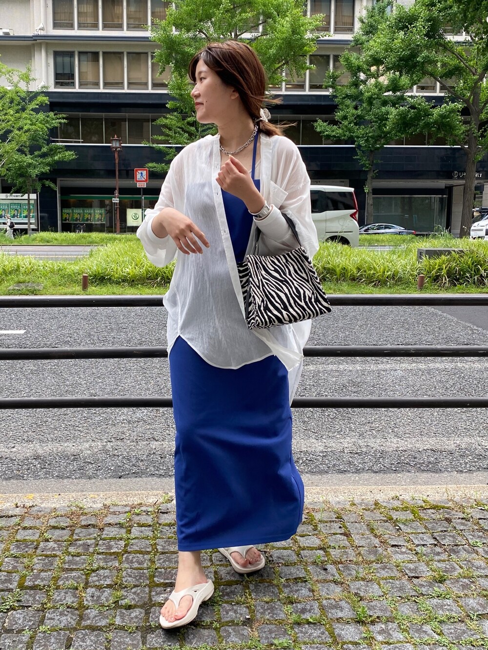 ブルー系のワンピース、ホワイト系のシャツ/ブラウス、ホワイト系のサンダルを着用したレディースの夏コーディネートの2枚目の写真