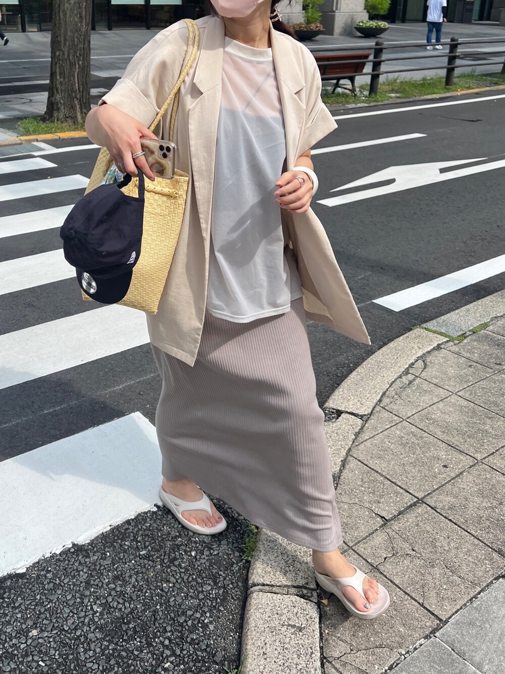 グレー系のワンピース、ベージュ系のテーラードジャケットを着用したレディースの夏コーディネートの3枚目の写真