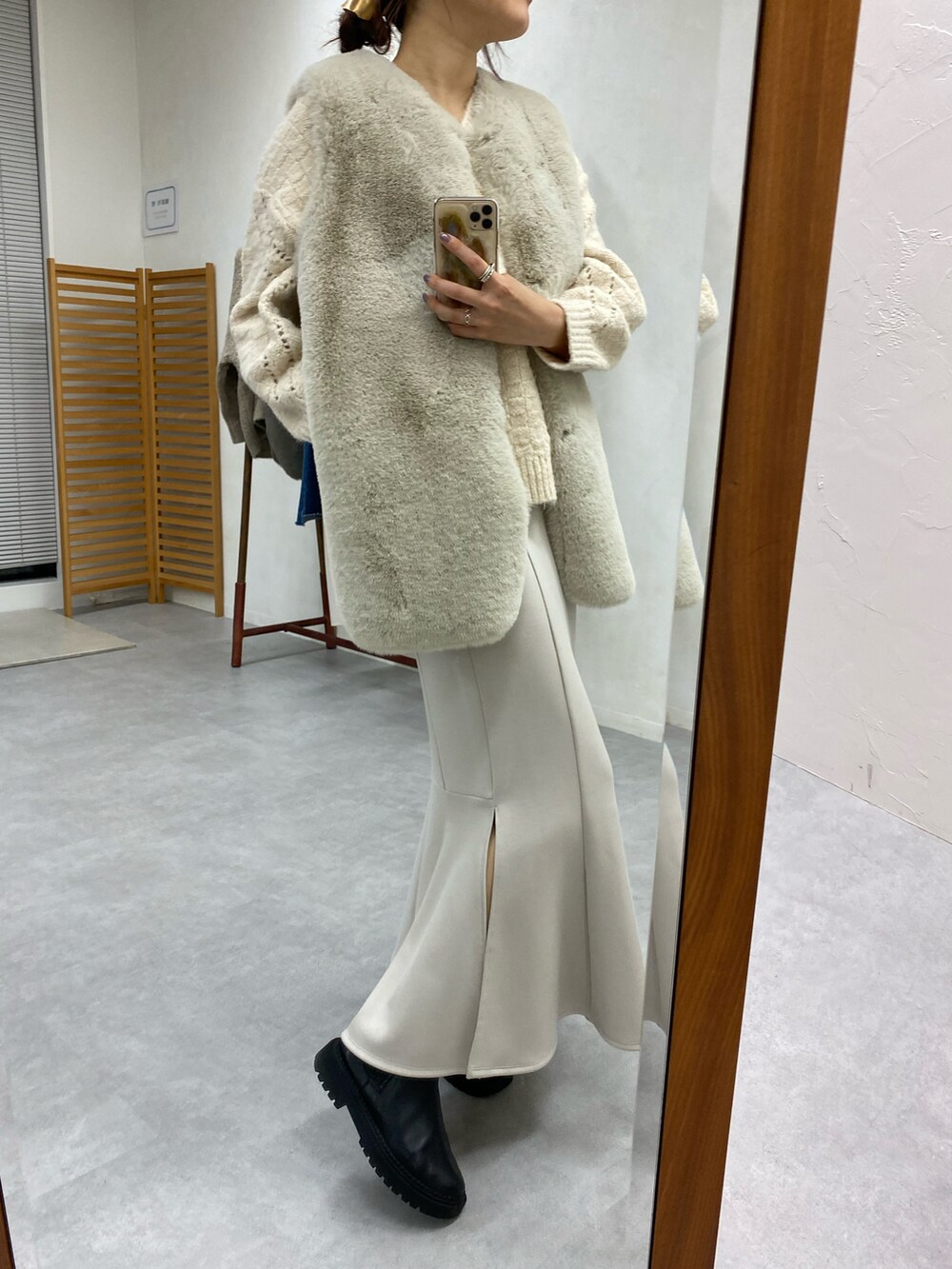 ベージュ系のベスト、ホワイト系のニット/セーター、ベージュ系のスカートを着用したレディースの秋コーディネートの2枚目の写真