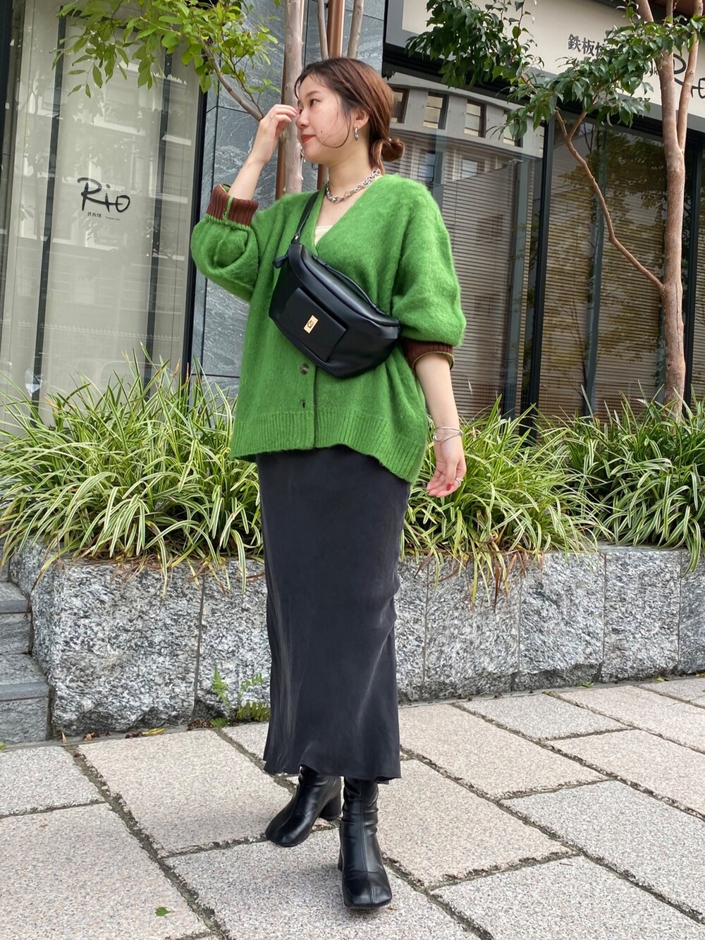 グリーン系のカーディガン/ボレロ、ブラック系のスカート、ブラック系のその他シューズを着用したレディースの秋コーディネートの2枚目の写真