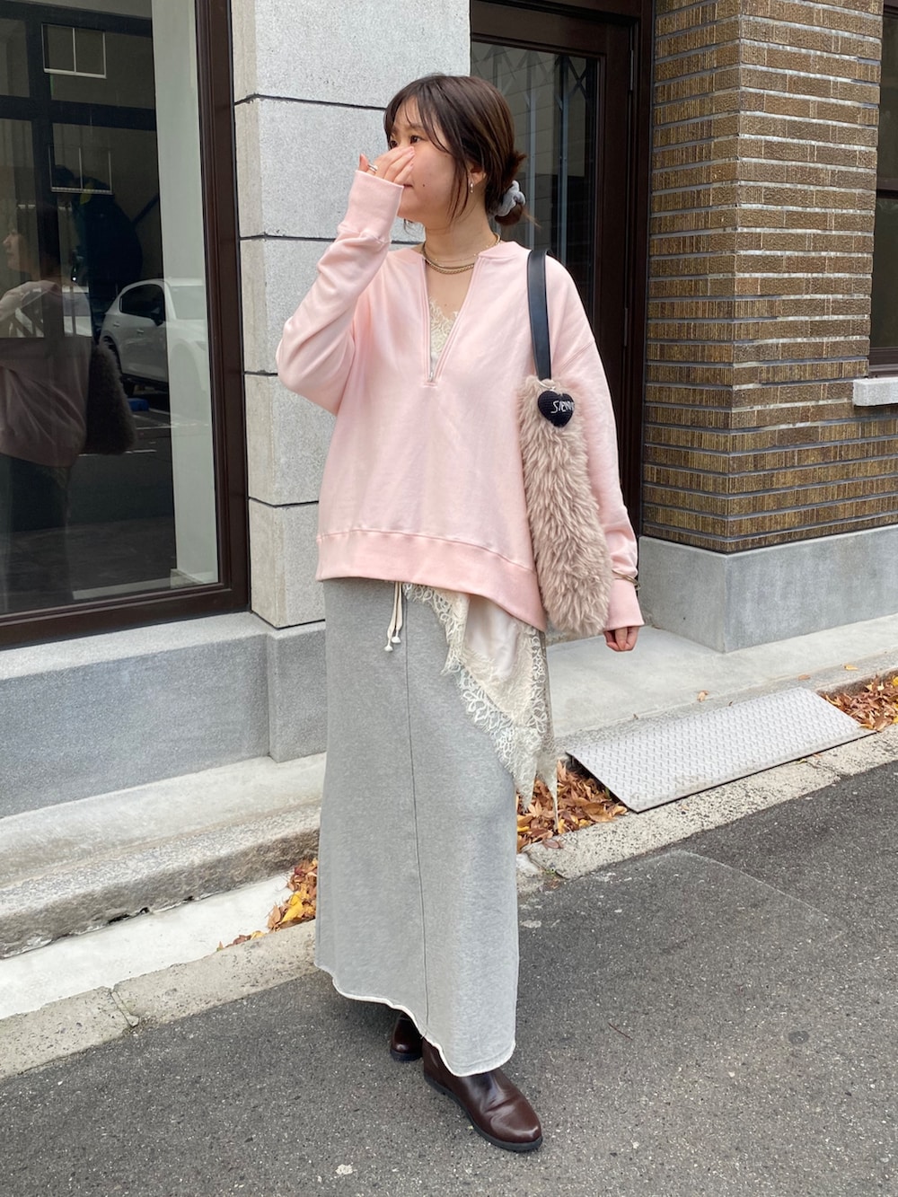 ピンク系のスウェット、ベージュ系のキャミソール、グレー系のスカートを着用したレディースの冬コーディネートの6枚目の写真