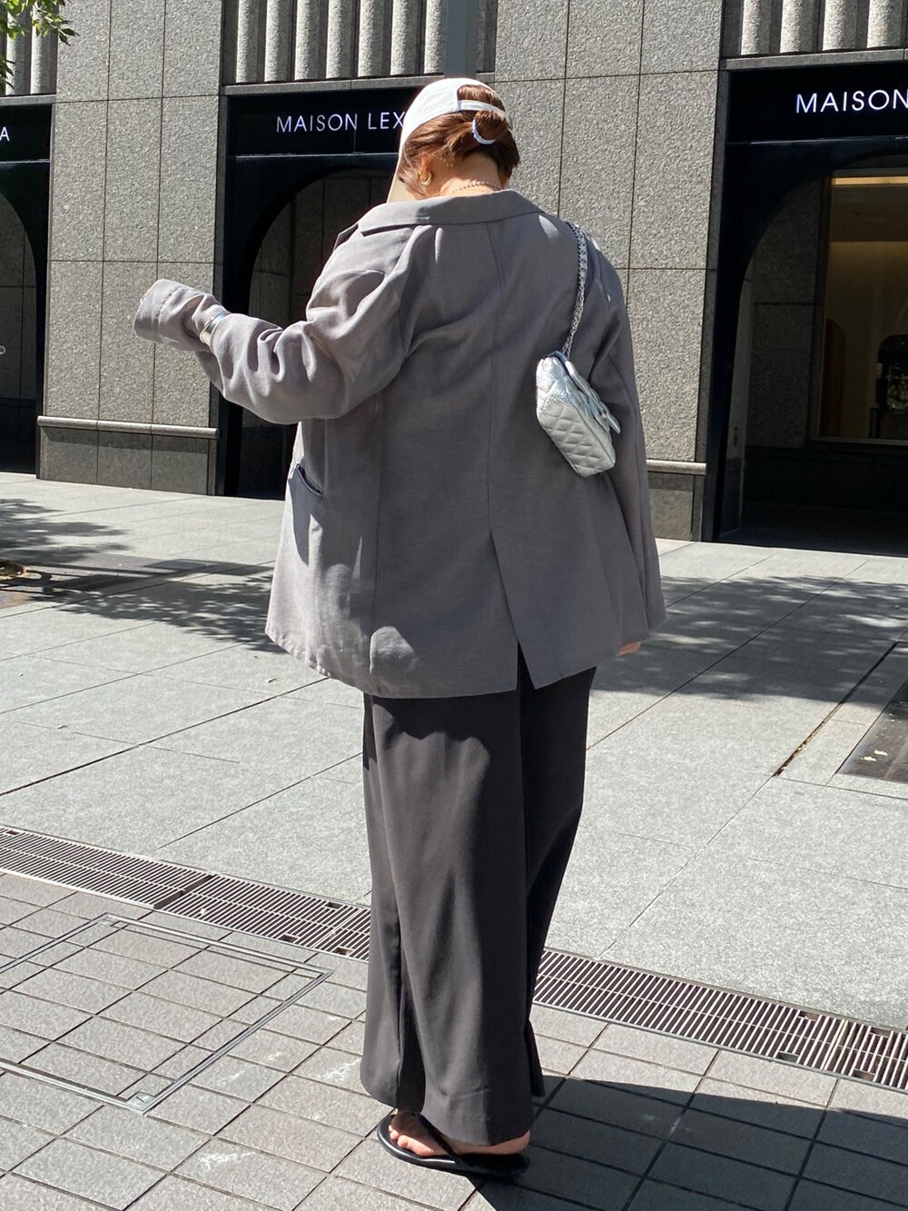 グレー系のワンピース、グレー系のテーラードジャケット、シルバー系のネックレスを着用したレディースの秋コーディネートの7枚目の写真