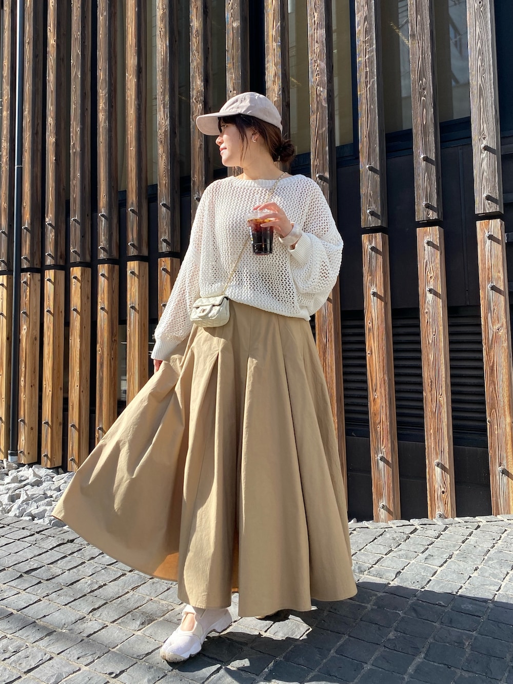 ホワイト系のニット/セーター、ベージュ系のスカート、ホワイト系のショルダーバッグを着用したレディースの春コーディネートの3枚目の写真