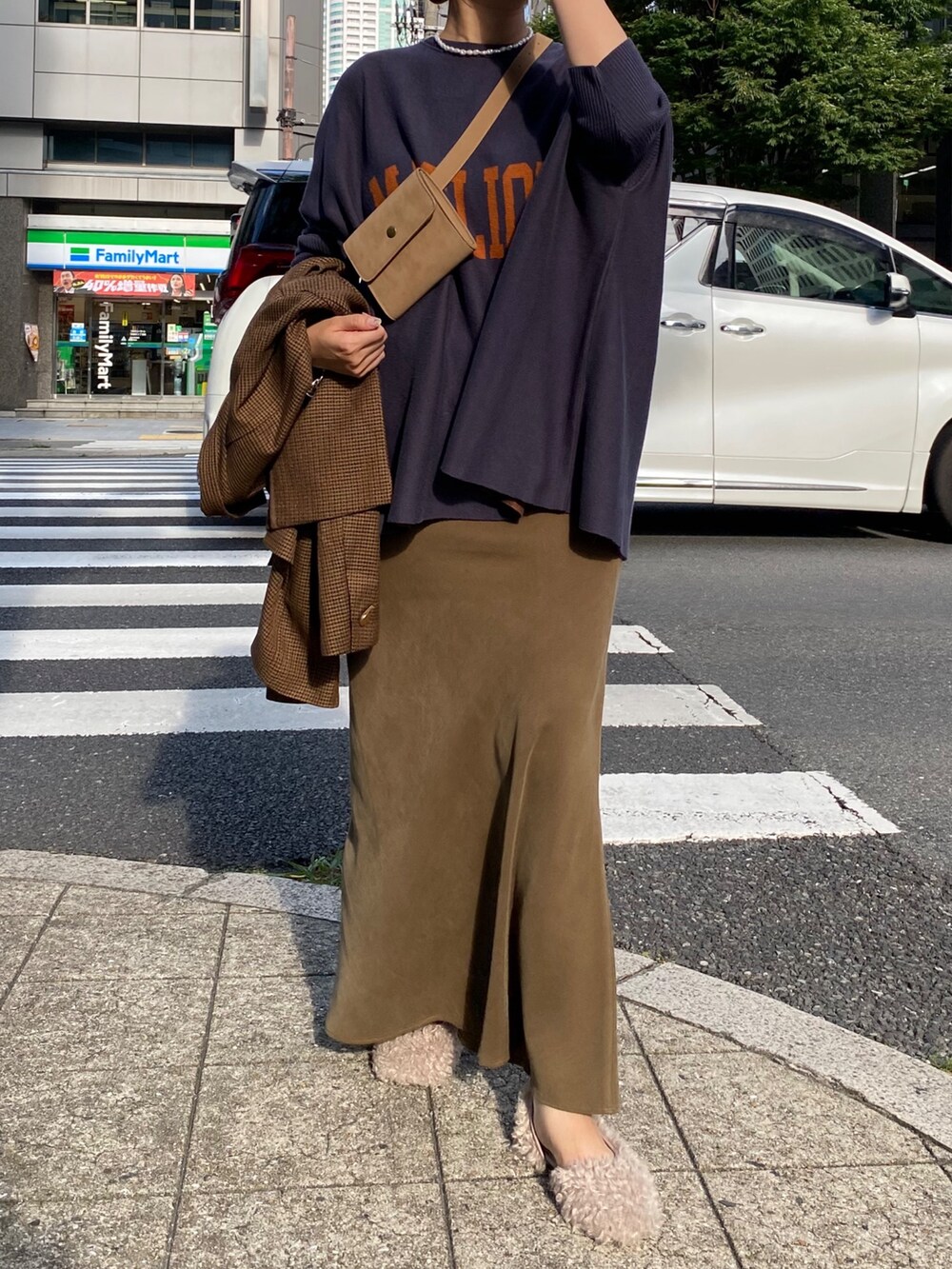 ブルー系のニット/セーター、グリーン系のスカート、ブラウン系のテーラードジャケットを着用したレディースの秋コーディネートの5枚目の写真