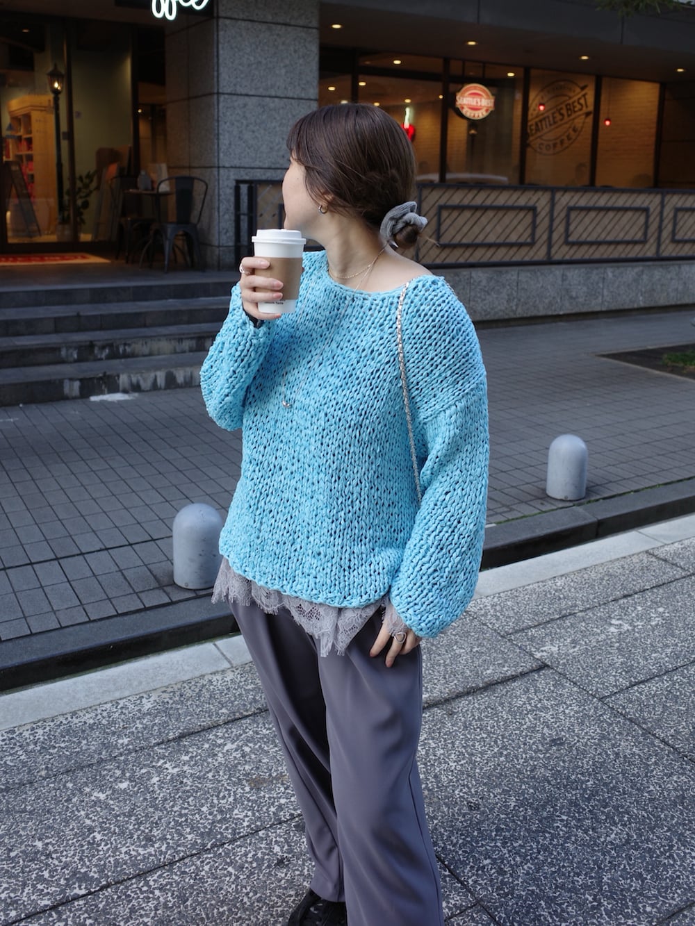 ブルー系のニット/セーター、グレー系のTシャツ/カットソー、グレー系のスラックスを着用したレディースの冬コーディネートの4枚目の写真