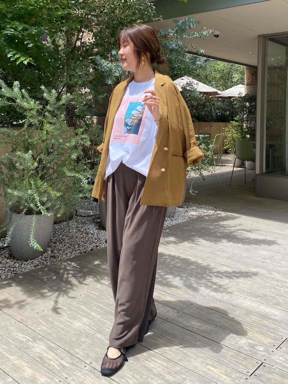 イエロー系のテーラードジャケット、ホワイト系のTシャツ/カットソー、ブラウン系のスラックスを着用したレディースの夏コーディネートの3枚目の写真