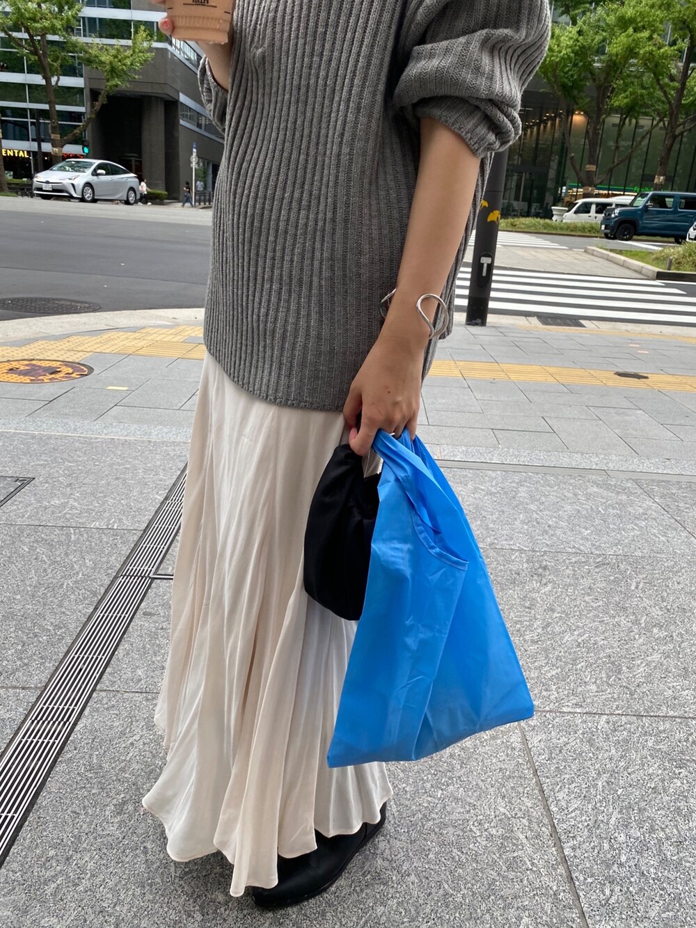 ベージュ系のワンピース、ホワイト系のスカート、ブラック系のブーツを着用したレディースの冬コーディネートの6枚目の写真